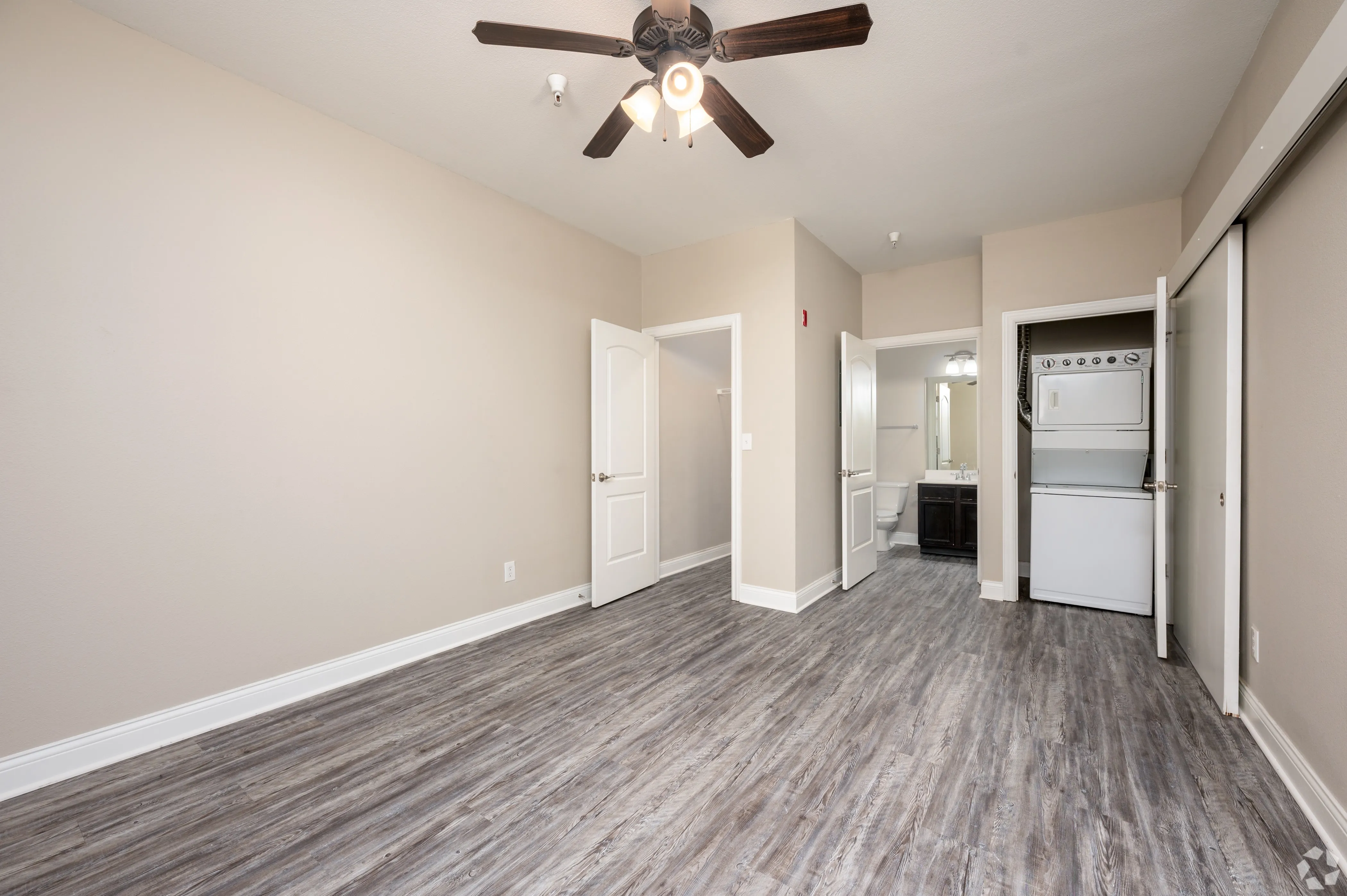 Interior view of a 9 North apartment showing the transition from a bedroom with wood-style floors to an in-unit laundry closet.