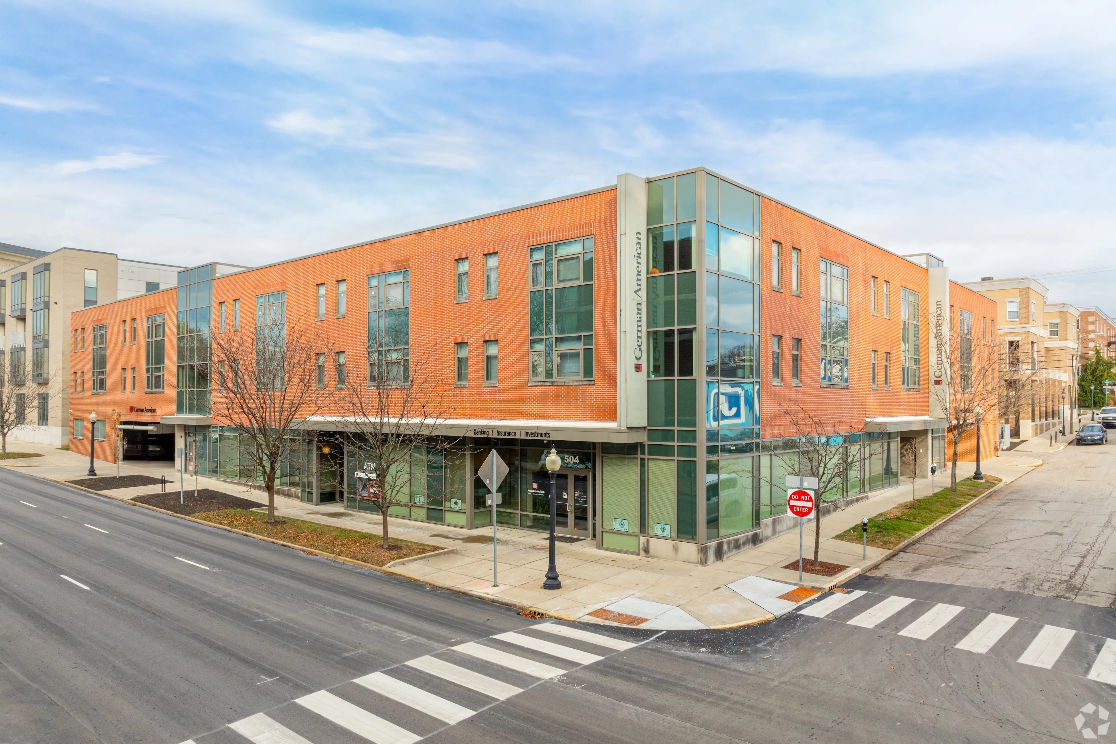 Exterior view of 9 North, a modern orange brick and glass corner apartment building in Bloomington, Indiana.