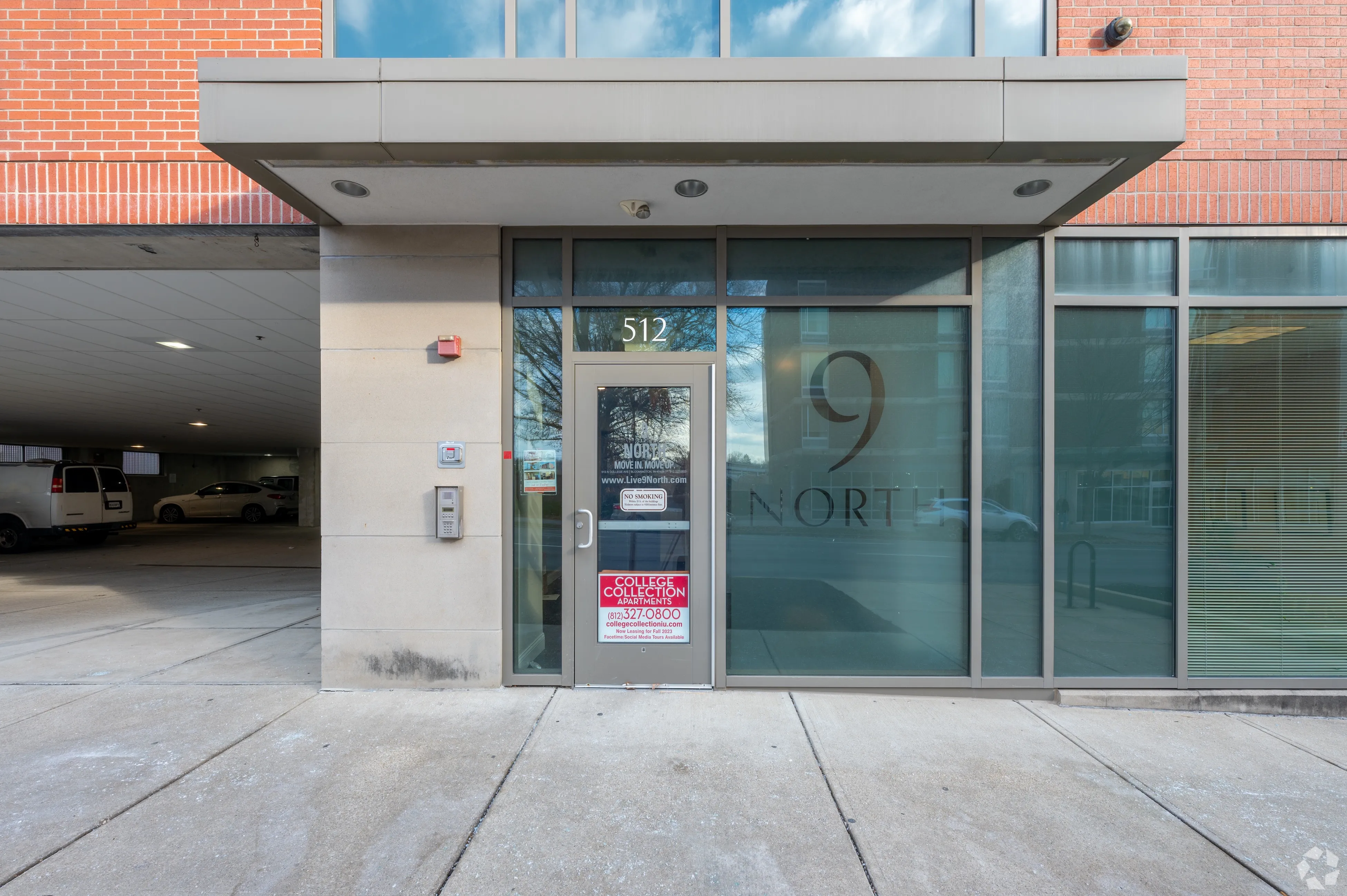 Secure glass entryway to 9 North apartments featuring digital intercom system and professional branding at 512 N College.