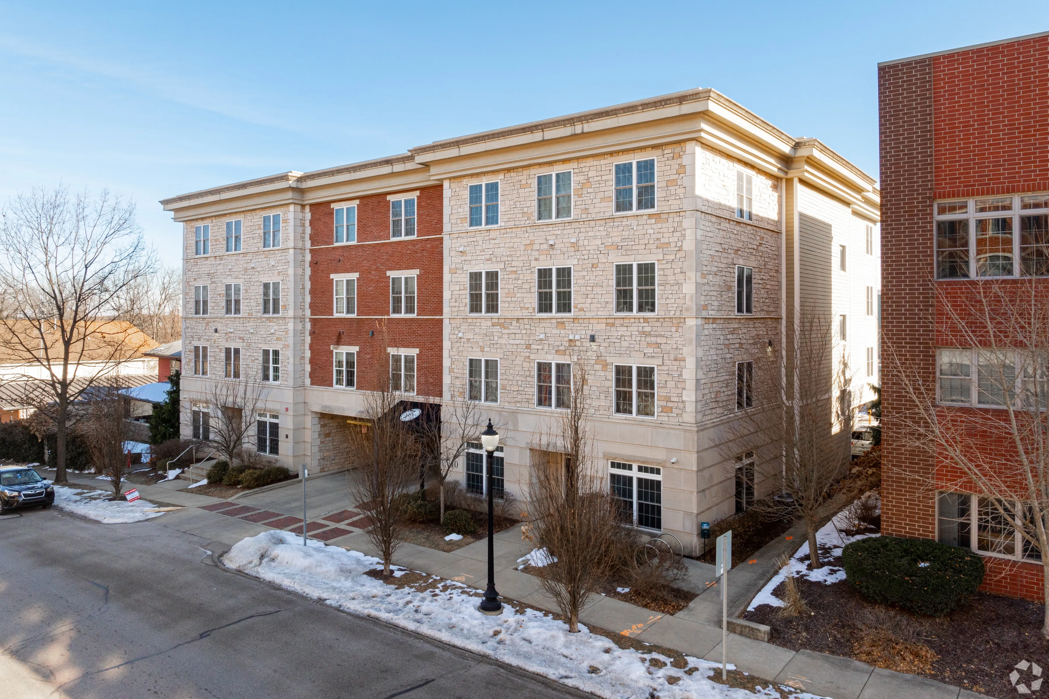 Street-side view of 7 Ten multi-story residential building with a mix of brick and stone exterior in Bloomington.
