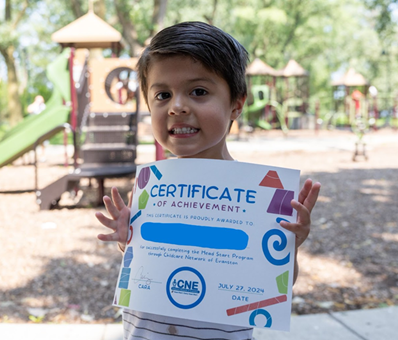 Photo of a child smiling holding a certificate