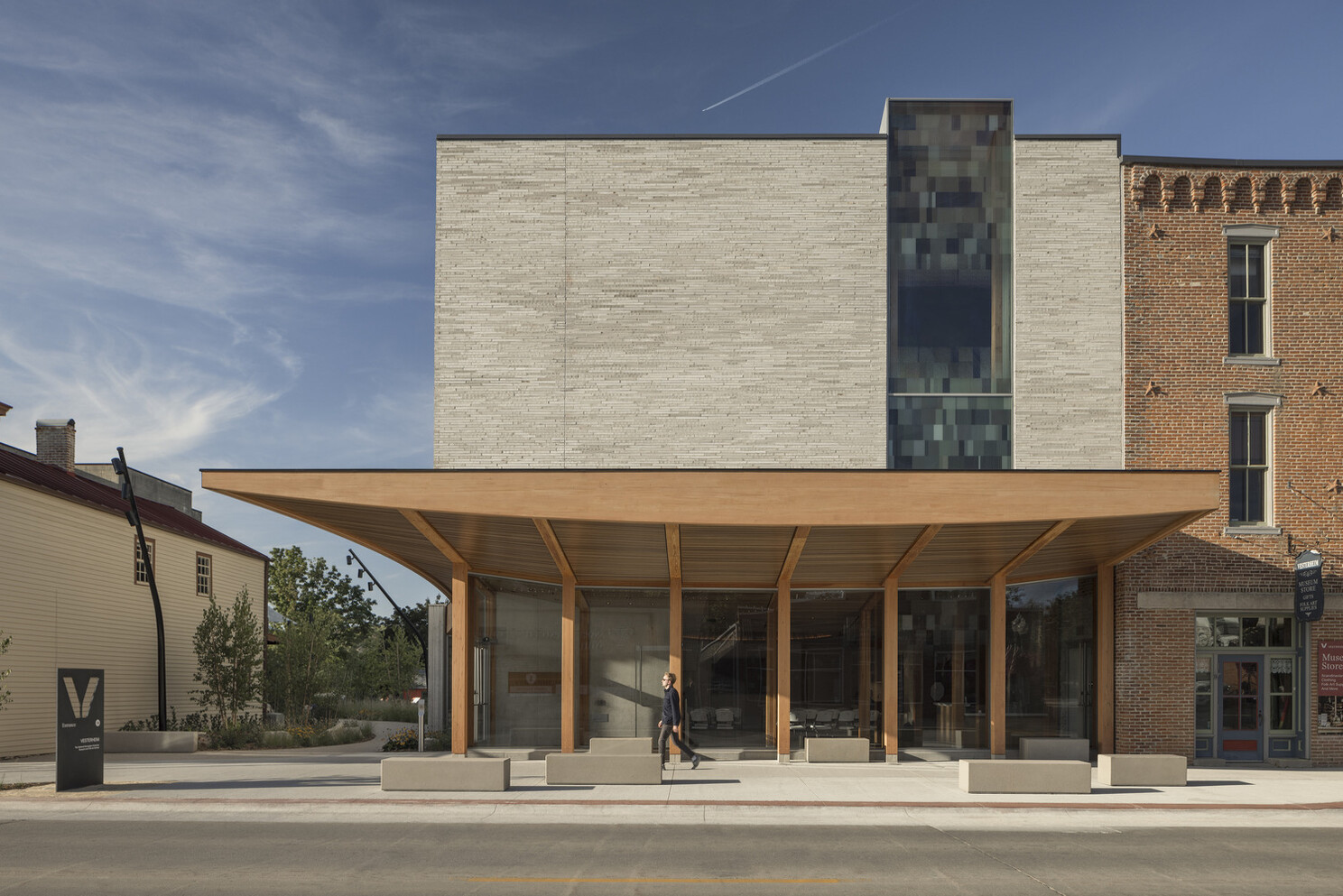 The corner of the building from the exterior and its wooden hanging features from the exterior of the building.