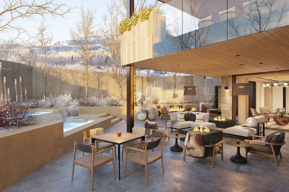 A snowy mountain backdrop in Colorado with a step side pool and a corner of 2 levels. A patio with chairs and fireplaces spaces throughout.