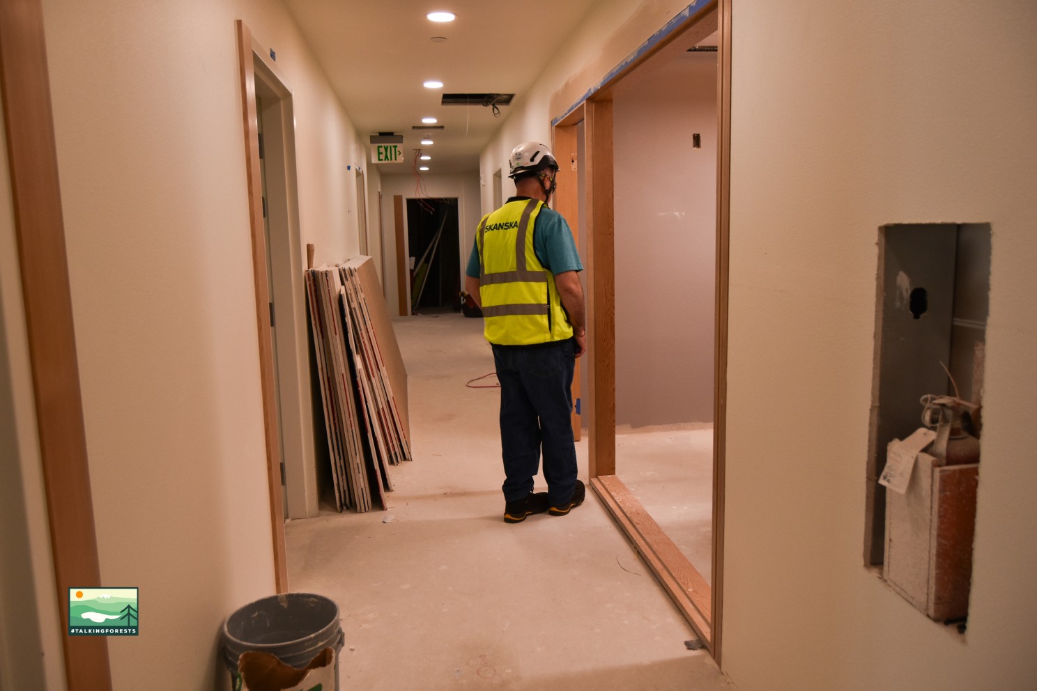 Hallways inside the building with no exposed mass timber beams or columns. Just wooden framing and some materials left out in the hallway due to active construction.
