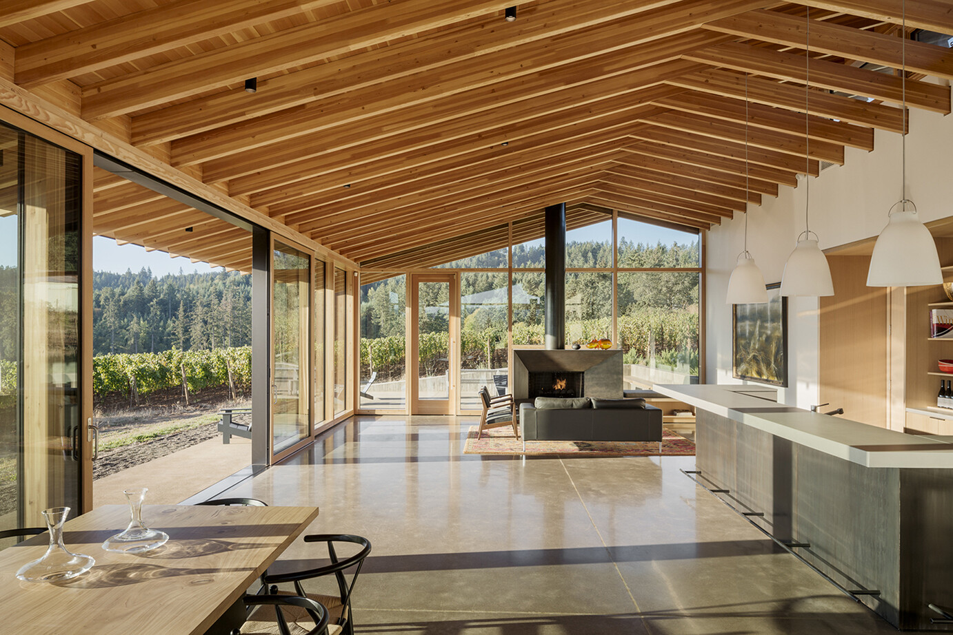 A warm interior mass timber CLT and GLT photo. Photography Credits: Jeremy Bitterman Wood colors make you feel seamless to the outside green grapes an dthe green trees. 