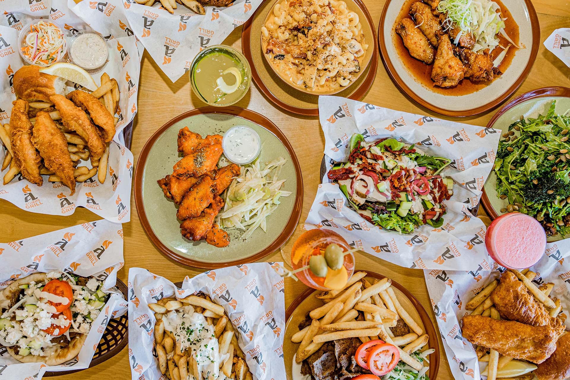 A table full of food including french fries, chicken, and salad.
