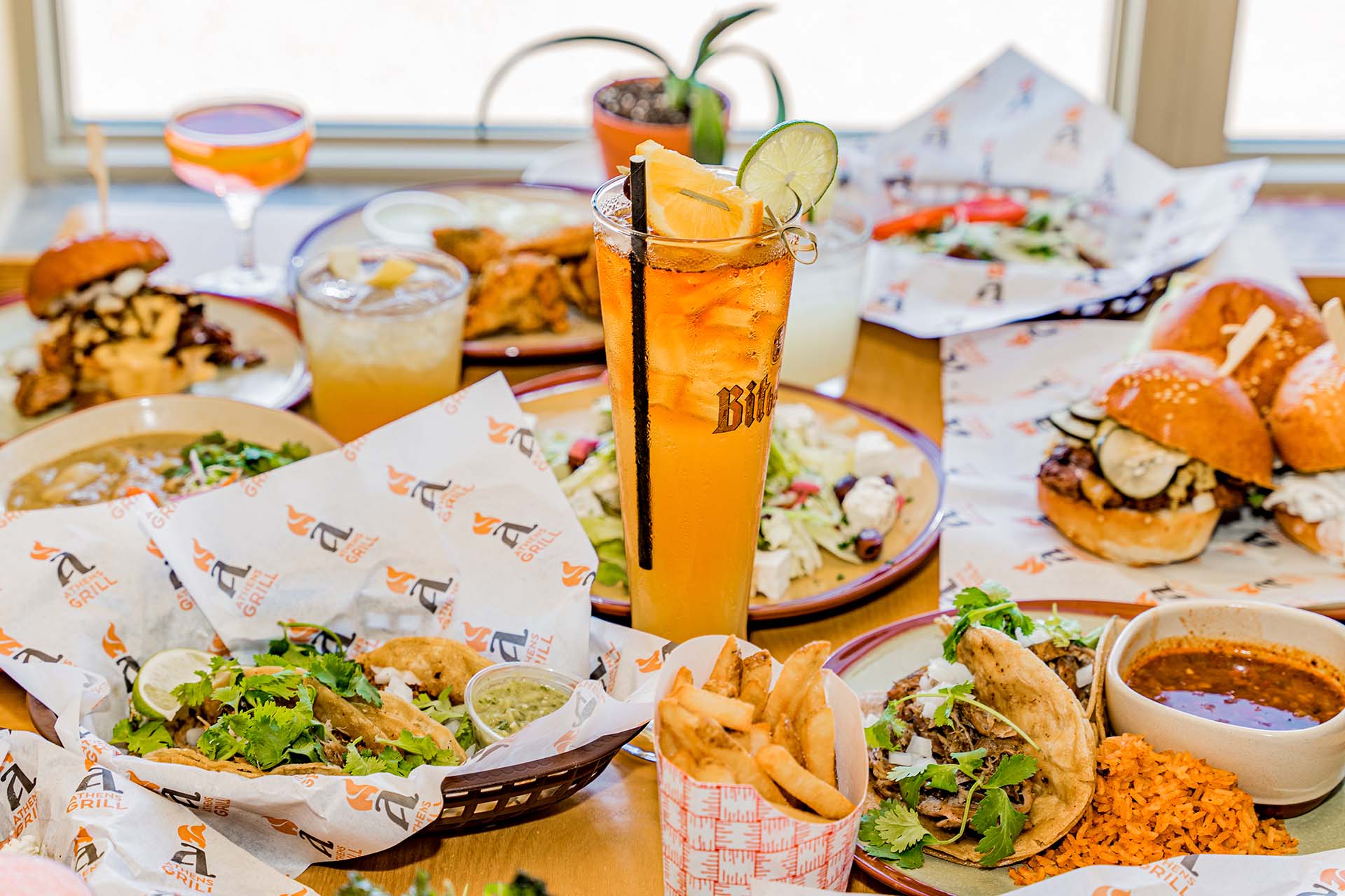 A table full of food and drinks with a pineapple drink in the center.