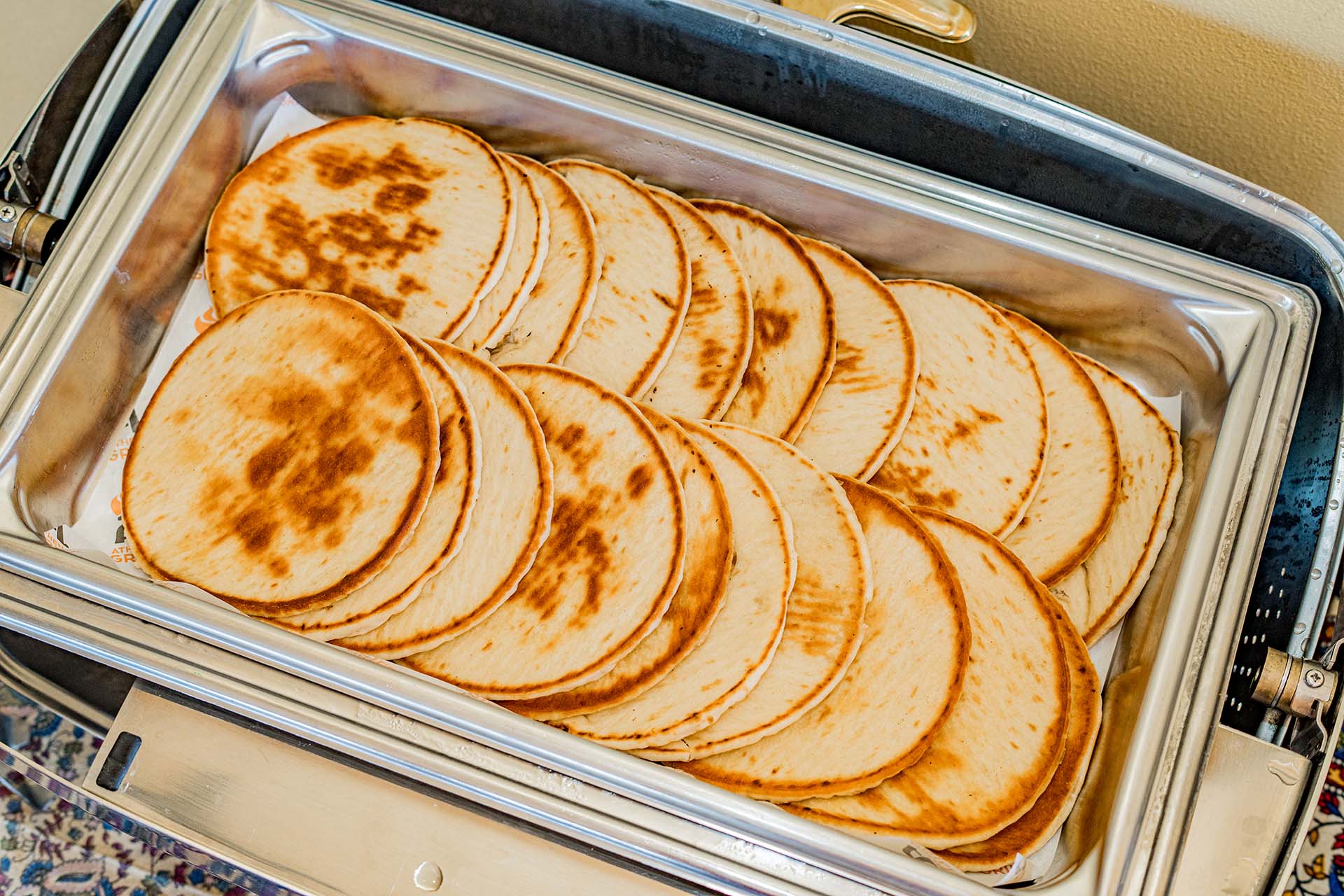 A silver tray filled with tortillas.