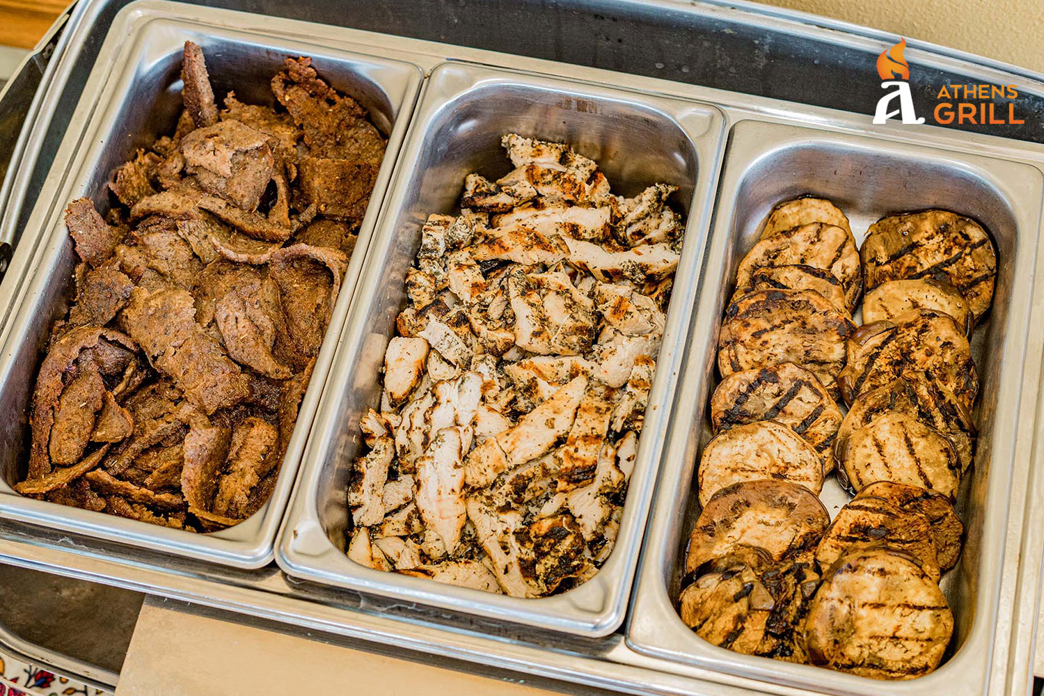 A tray of food with three compartments, one with chicken, one with beef, and one with pork.