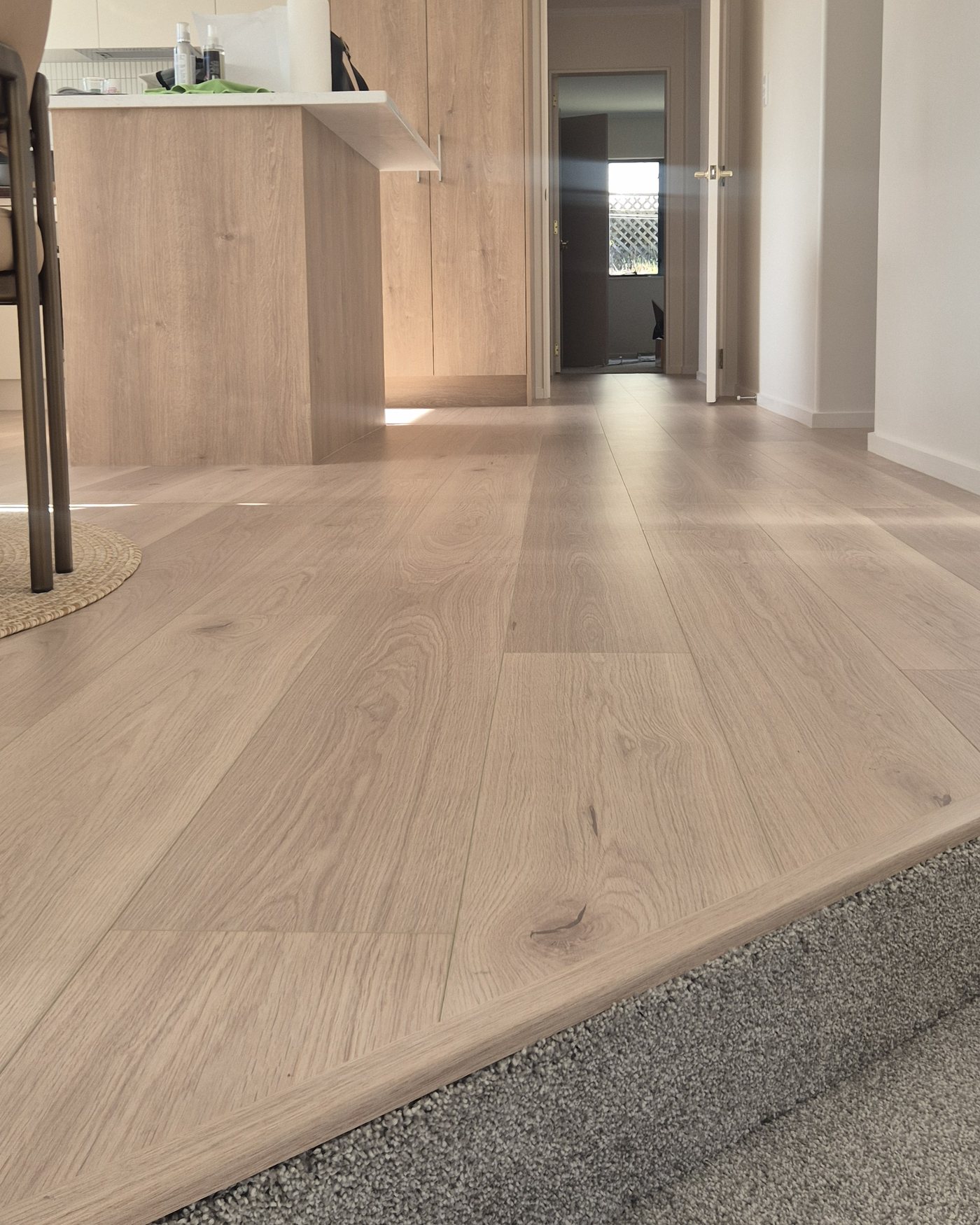 Armstrong Queenstown laminate running from an open plan kitchen to a carpeted living room
