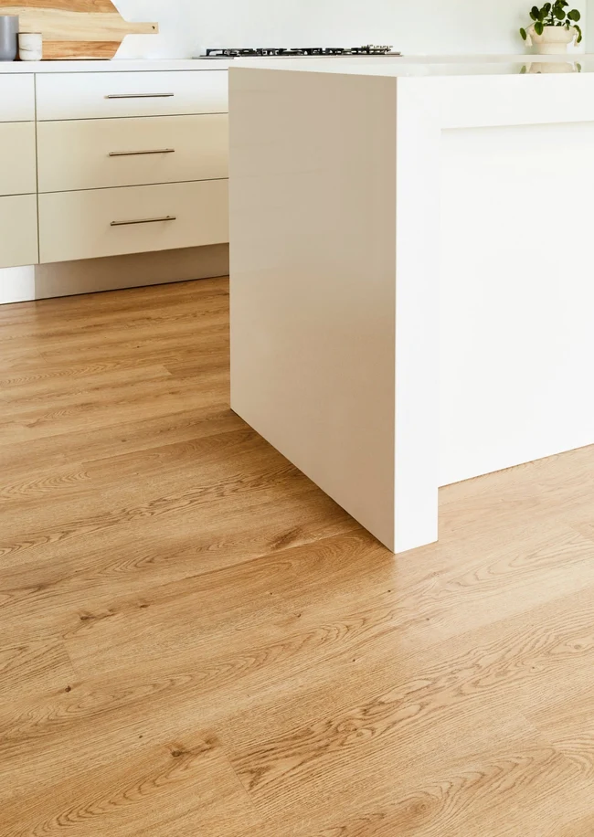 Honey oak hybrid SPC plank running under a kitchen island
