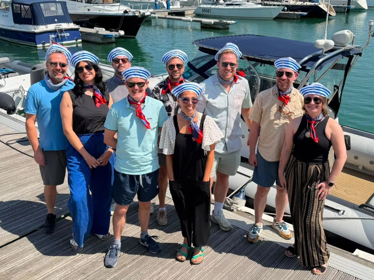 The INCEPTION team in matching sailor hats on a marina pontoon during a team trip