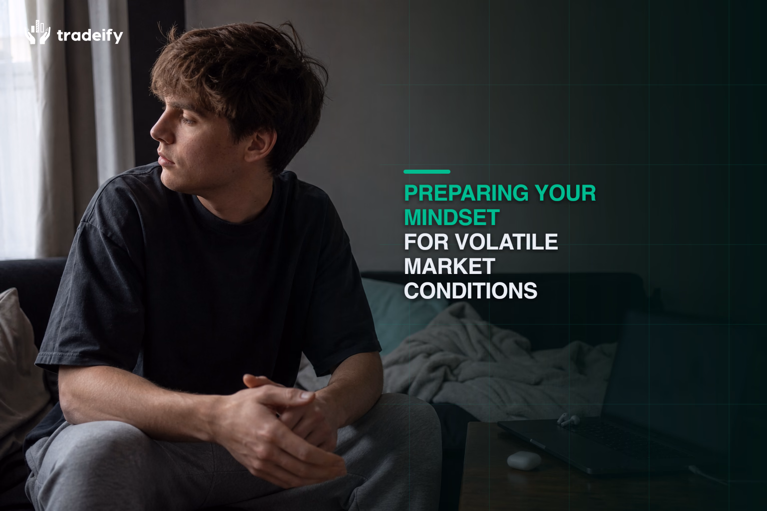 Young trader pausing calmly with hands away from a laptop during a volatile futures session