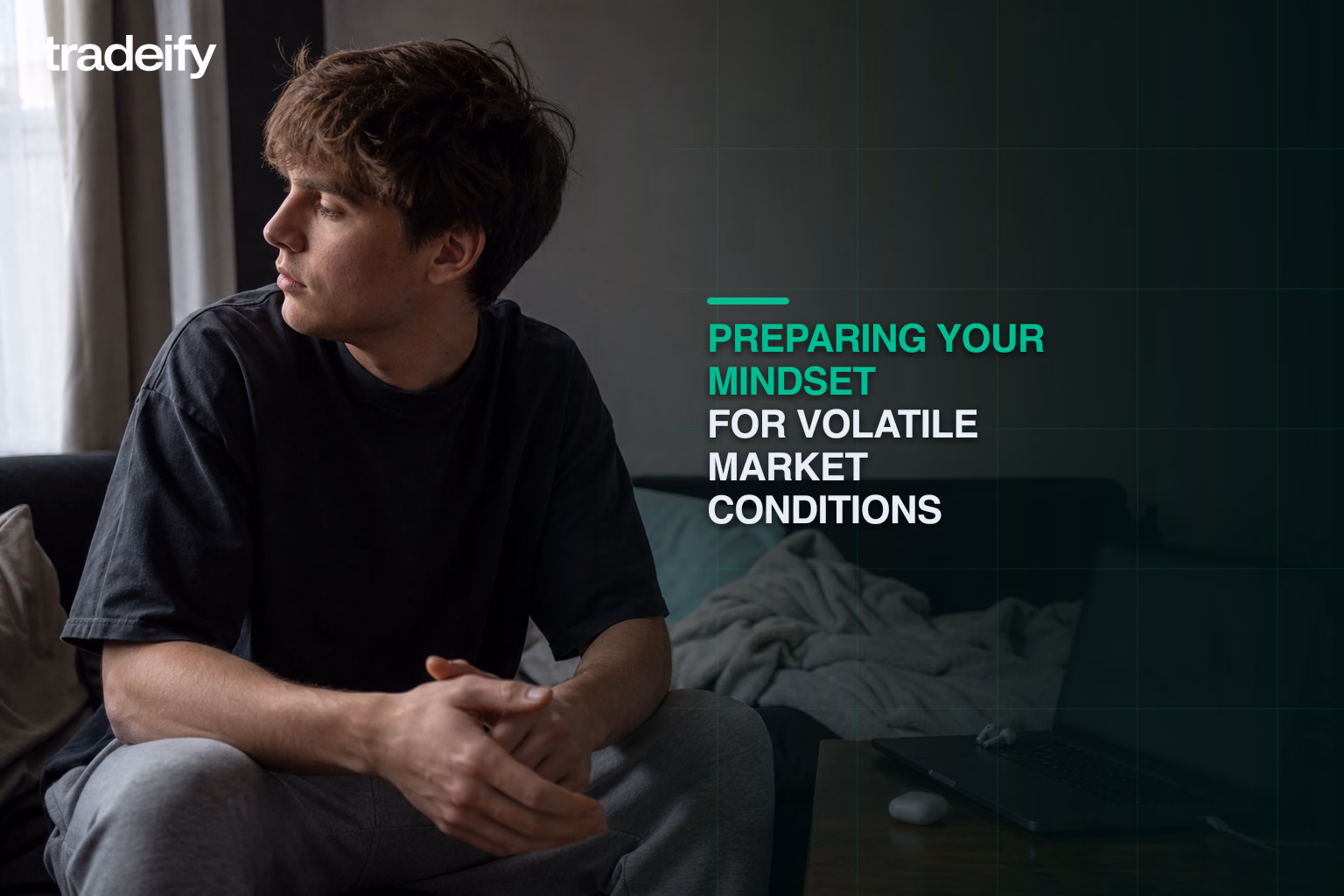 Young trader pausing calmly with hands away from a laptop during a volatile futures session