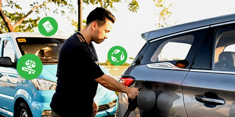 Man charging an electric vehicle with green eco and legal compliance icons, representing EVIDA Law benefits in the Philippines
