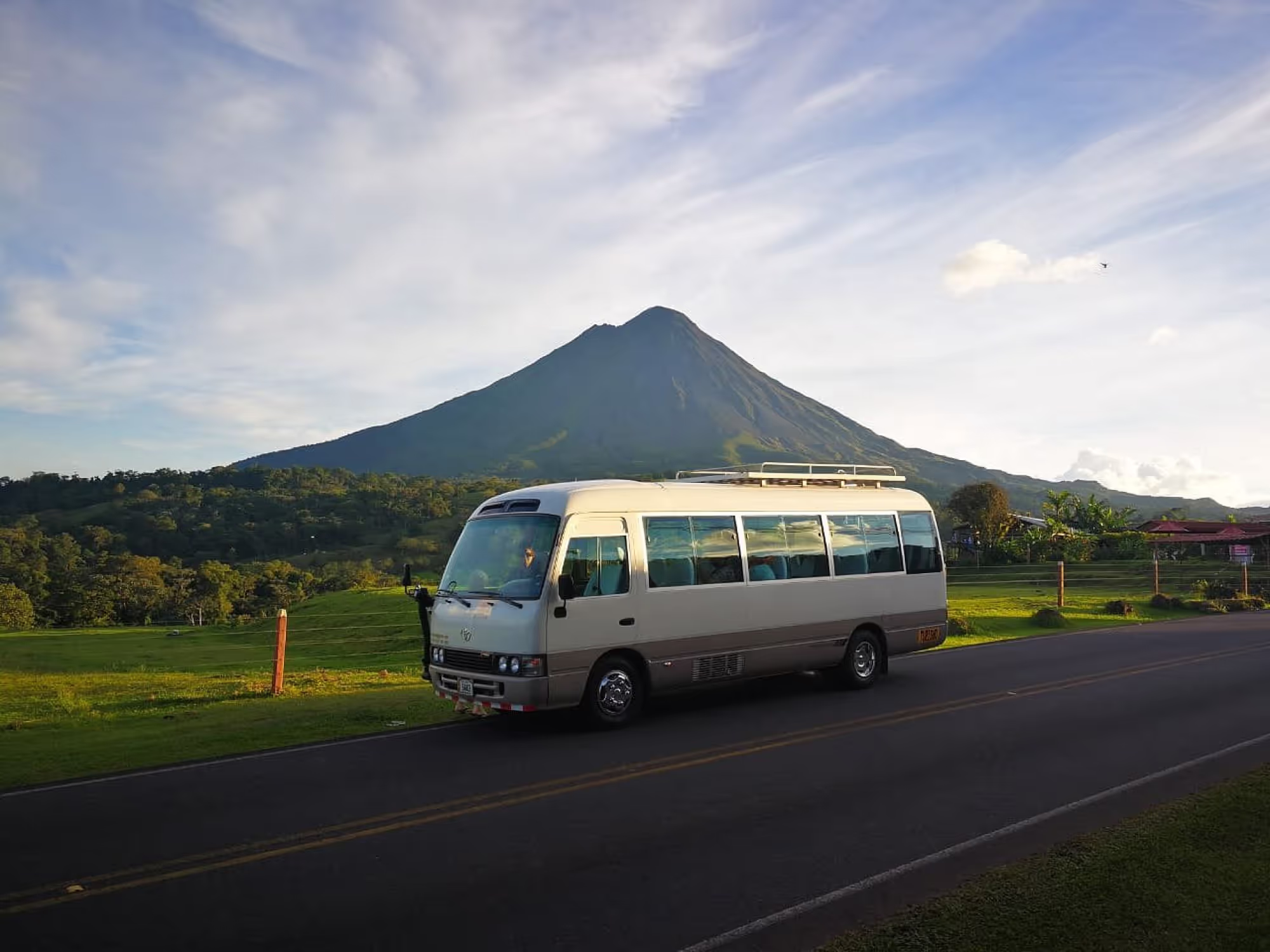 A minibus on the road with a volcano in the background
