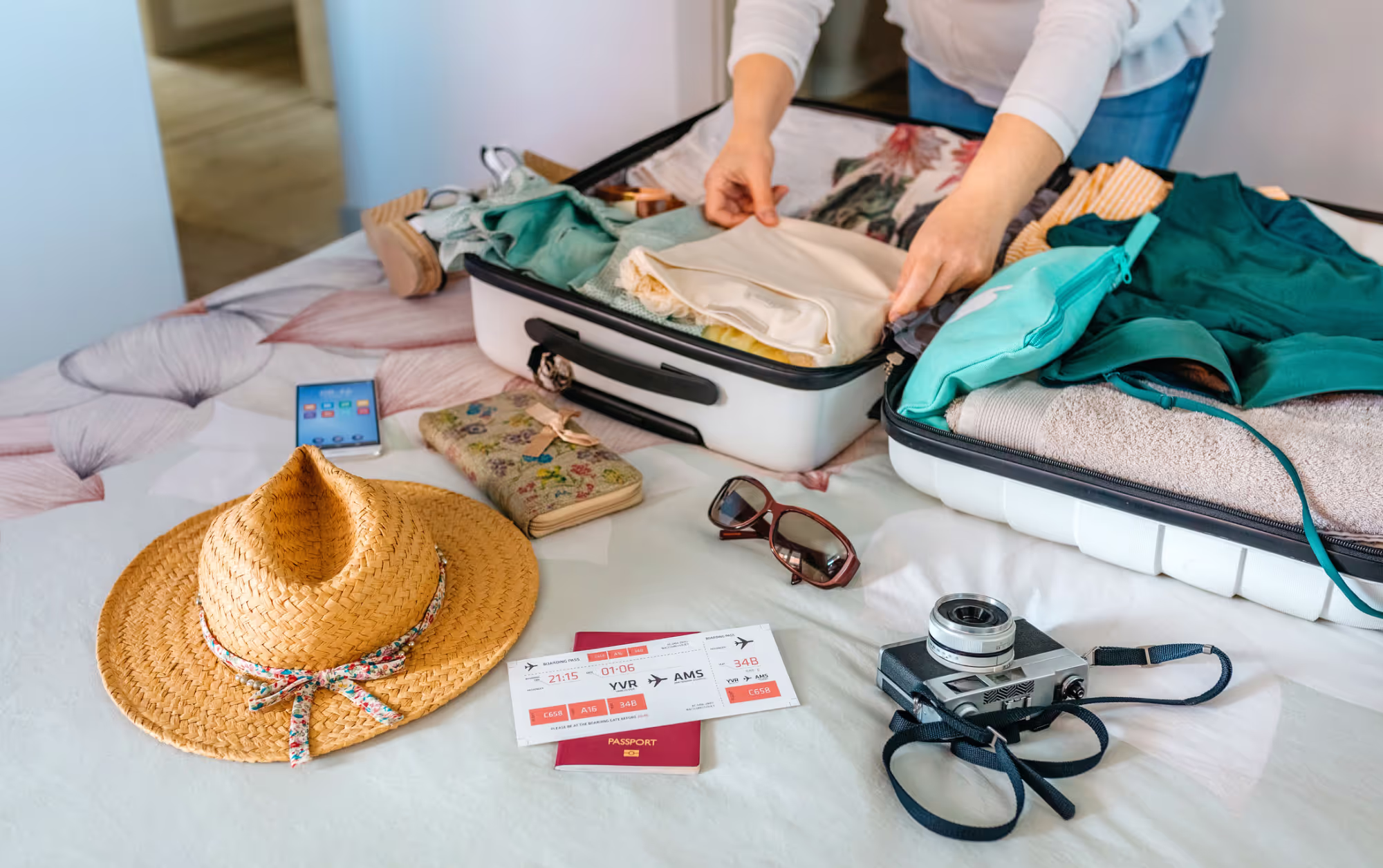 A suitcase with travel items on a bed