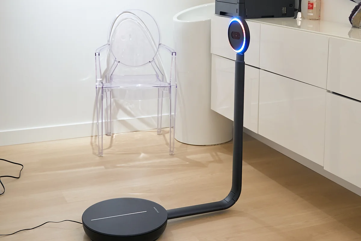 A ShapeScale scanner installed in a clinic room, next to a clear acrylic chair and white cabinets.