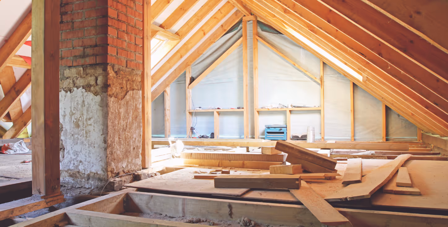 Offener Dachumbau mit sichtbarer Holzkonstruktion und großen Fenstern – moderner Innenausbau im Bestand.