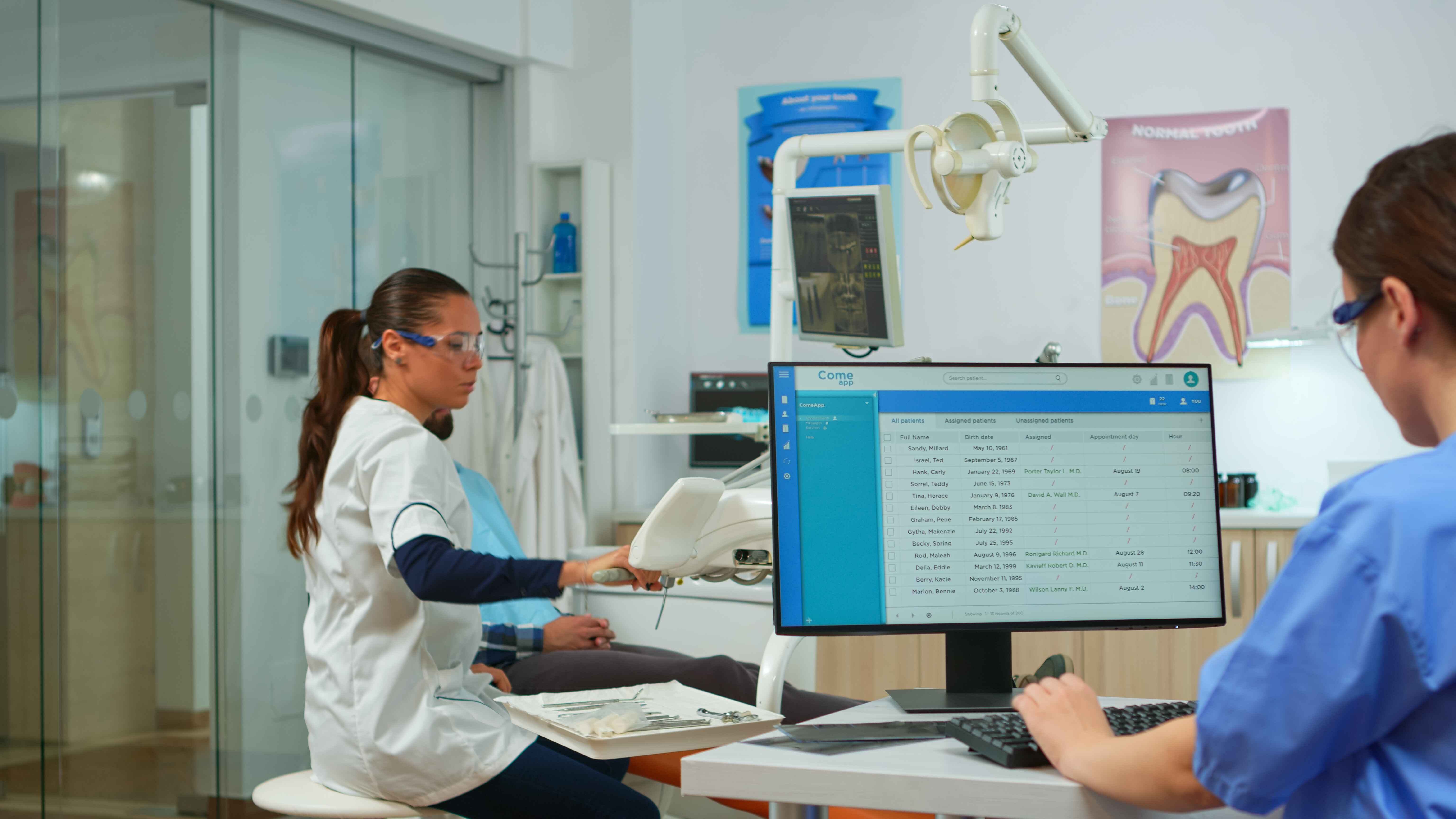 Two dental professionals managing patient financing options on a computer, improving DSO financial health.