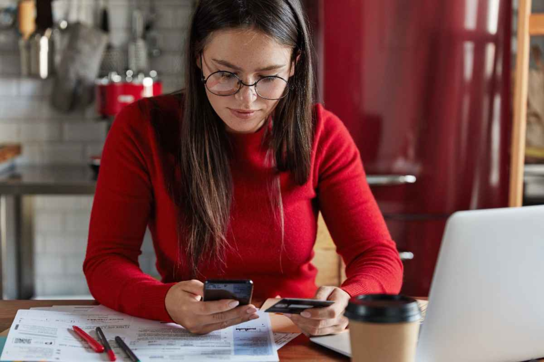 Woman using a smartphone to make a digital payment, illustrating embedded finance in payments.