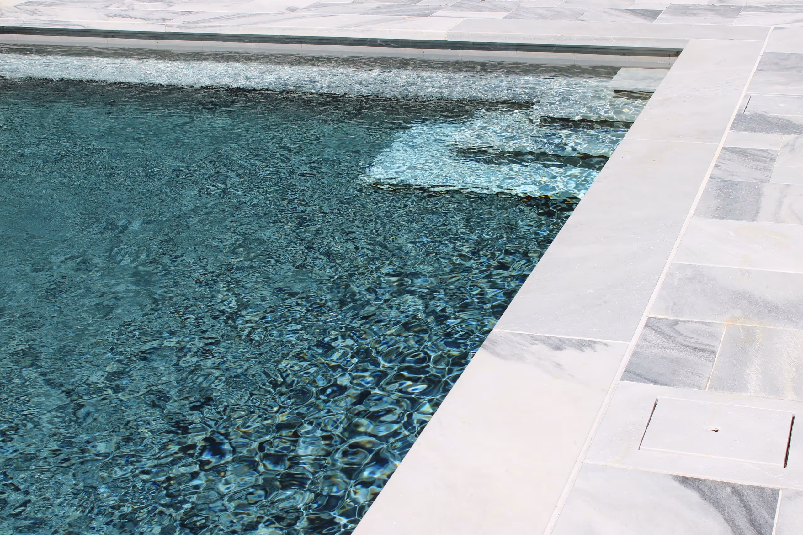 Close-up of luxury pool tile and spa edge with clear blue water in New Canaan, CT by New Canaan Pool Service