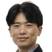 Portrait of a smiling man with short black hair wearing a dark jacket.