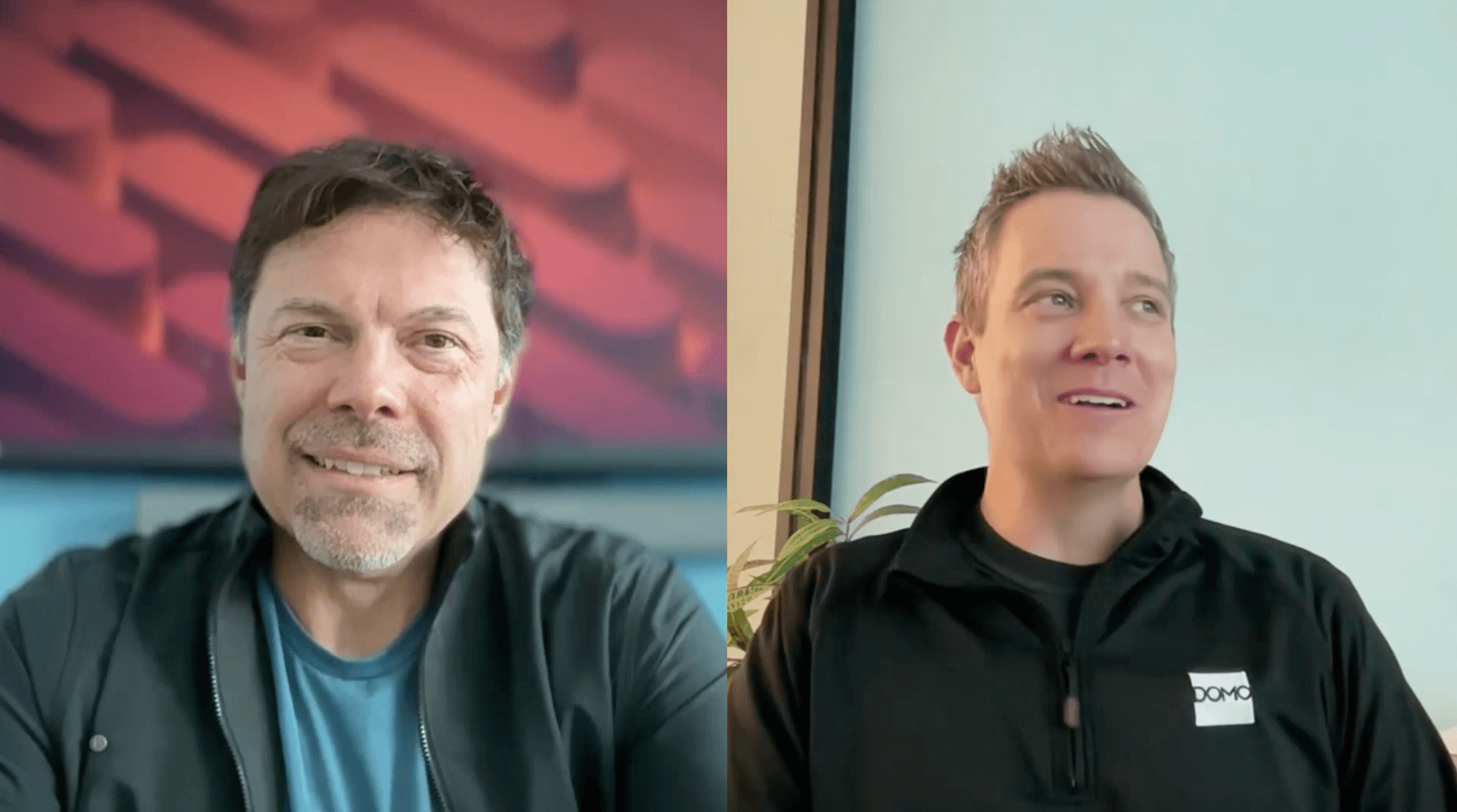 Two men in casual clothing smiling during a video call, one with a red abstract background and the other with a light blue wall and plant behind.