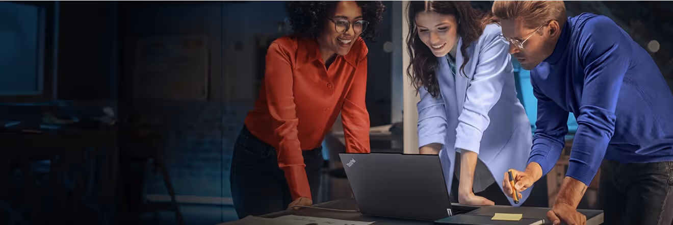 Three people looking at a Lenovo laptop
