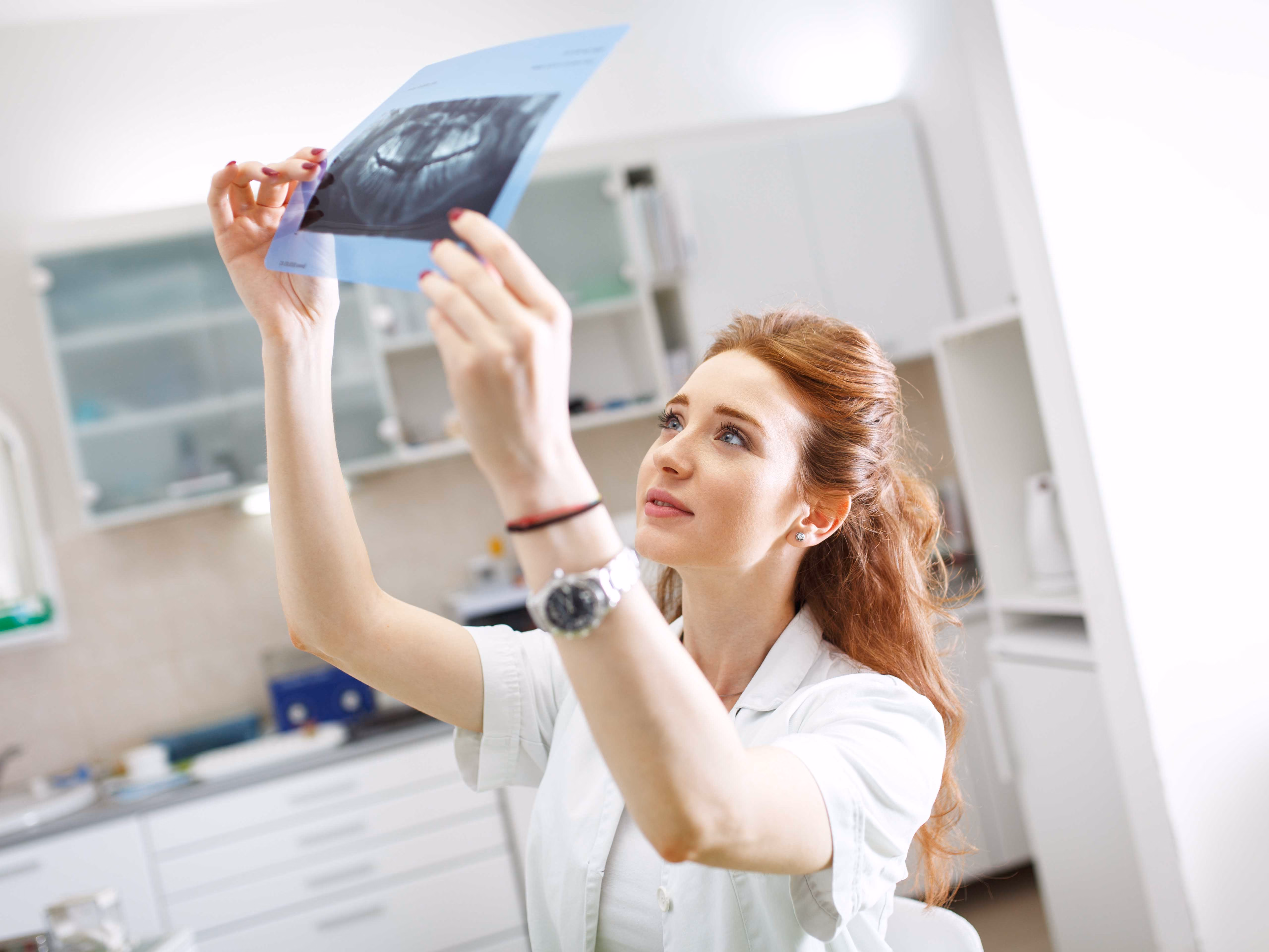 Dentist reviewing customer mouth x-ray after root canal treatment. 
