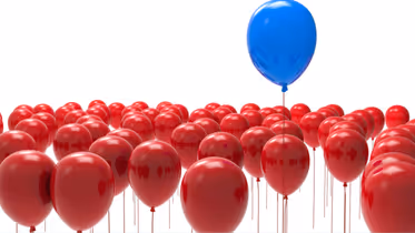 Blue balloon elevated over red balloons