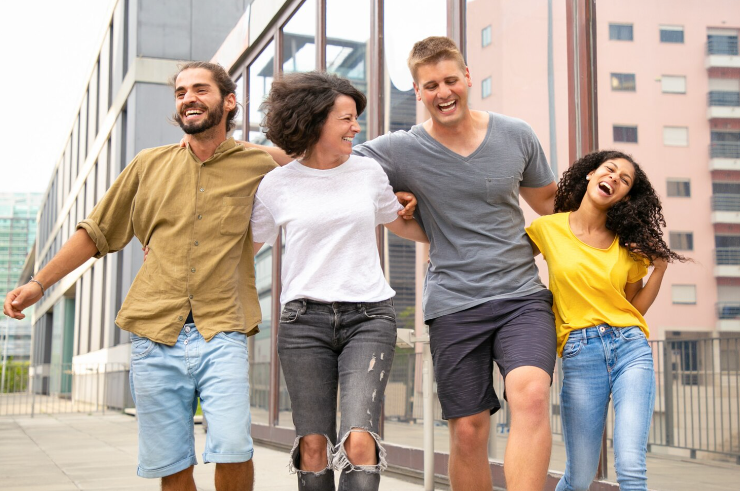 Four smiling people walking outdoors, with buildings in the background, reflecting the power of peer mentorship at an addiction treatment center in South Carolina