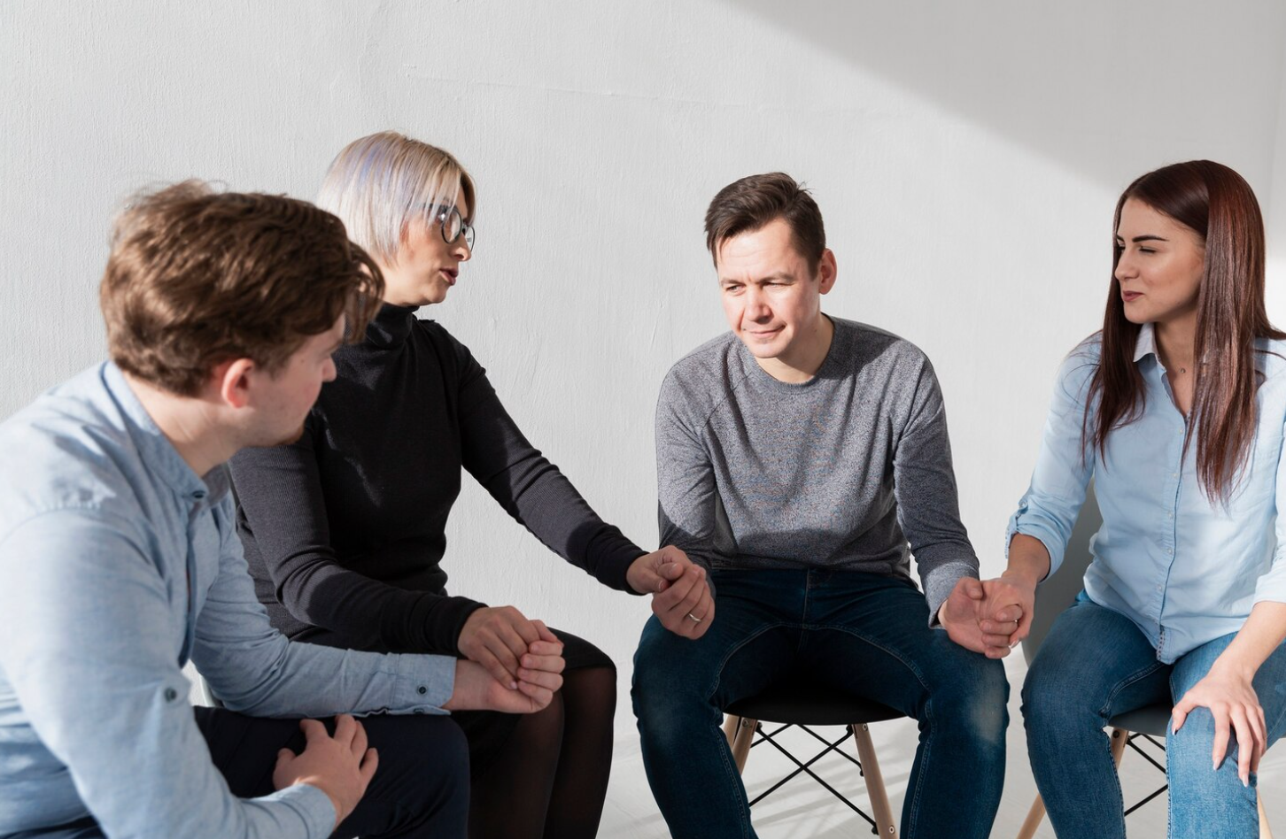 A group of four people attending a group therapy session of a PHP