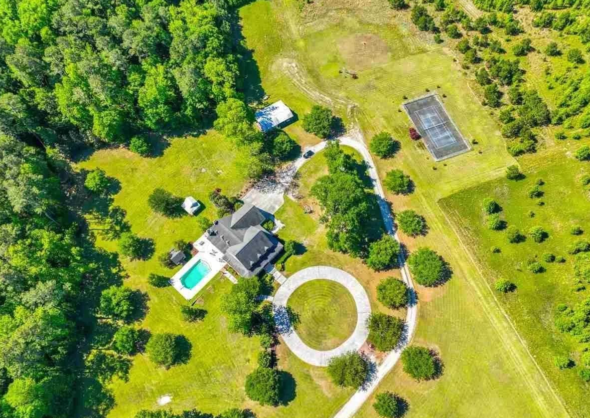 Aerial view of a peaceful, expansive estate surrounded by greenery, highlighting a serene environment that can support healing and recovery