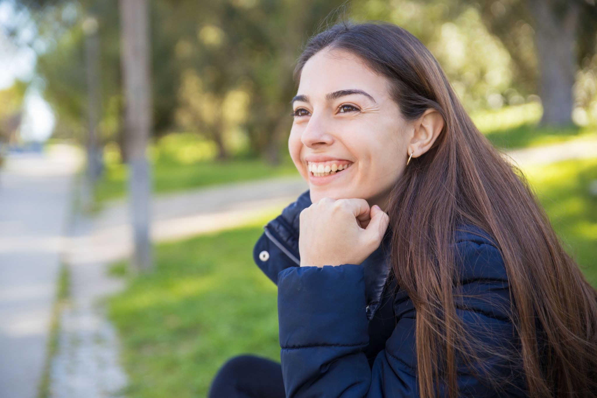 Young woman smiling outdoors, representing emotional healing, personal growth, and long-term recovery after addiction treatment