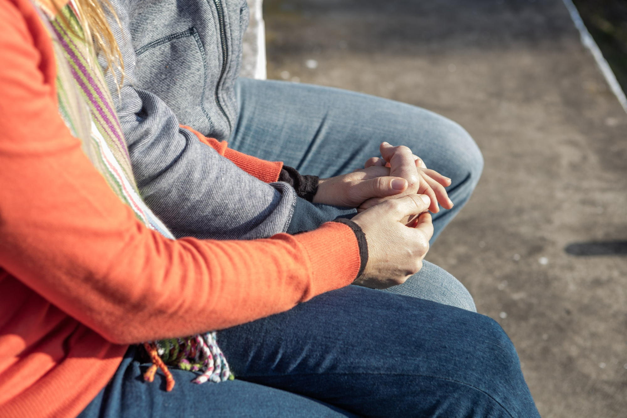 Close-up of two people sitting together outdoors, offering support and encouragement during addiction recovery