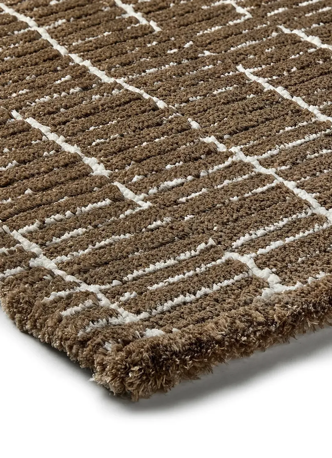 Close-up of a brown textured rug with a grid pattern created by white lines, showing its thick, plush fibers and corner edge.