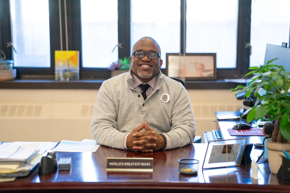 Principal Williams smiling at his desk in school office