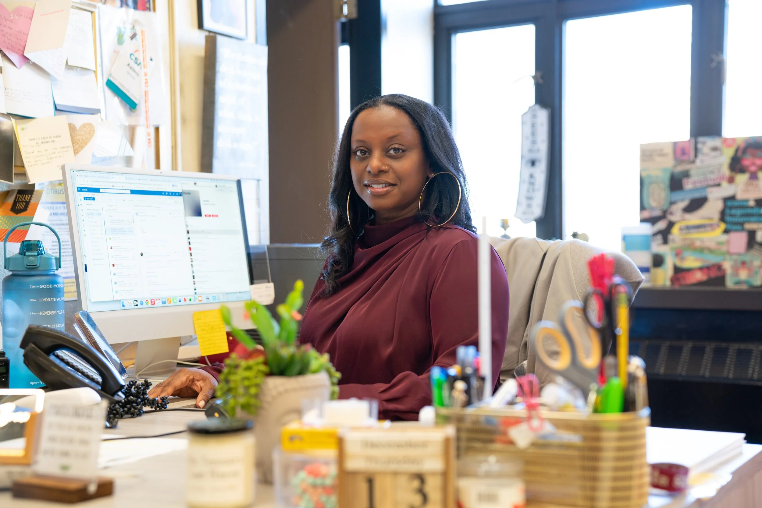 Staff member Yemmer smiling at her school office desk