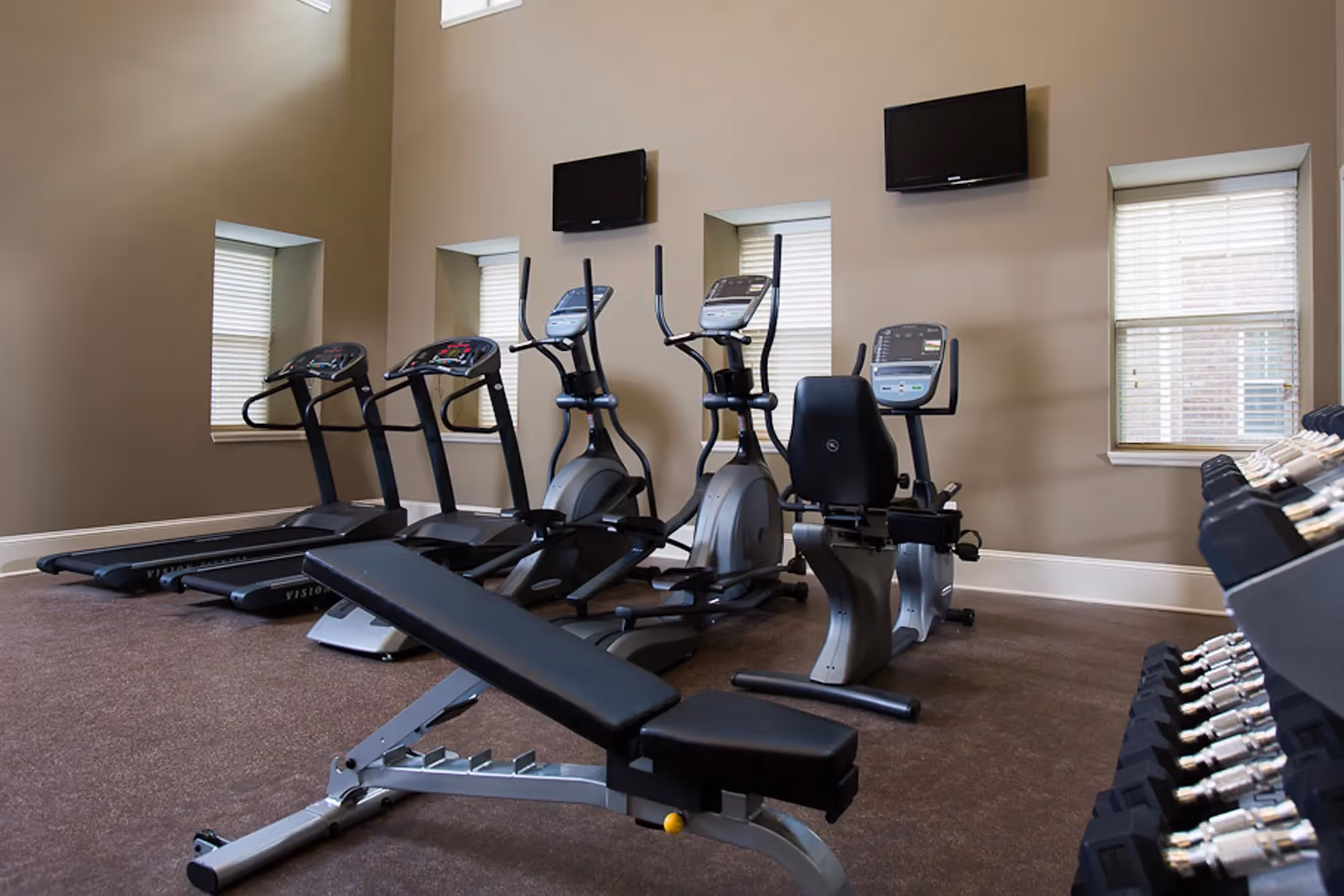 fitness center with treadmill, stationary bikes, and weights