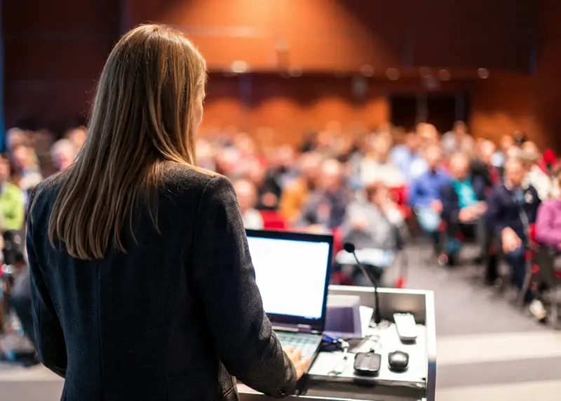 Dr. Nicole L'Etoile speaking to an audience at a conference.