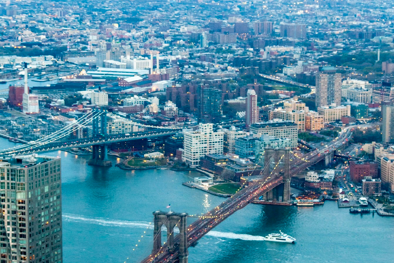 Iconic view of the Manhattan Bridge framed by brick warehouse buildings on cobblestone Washington Street in Dumbo