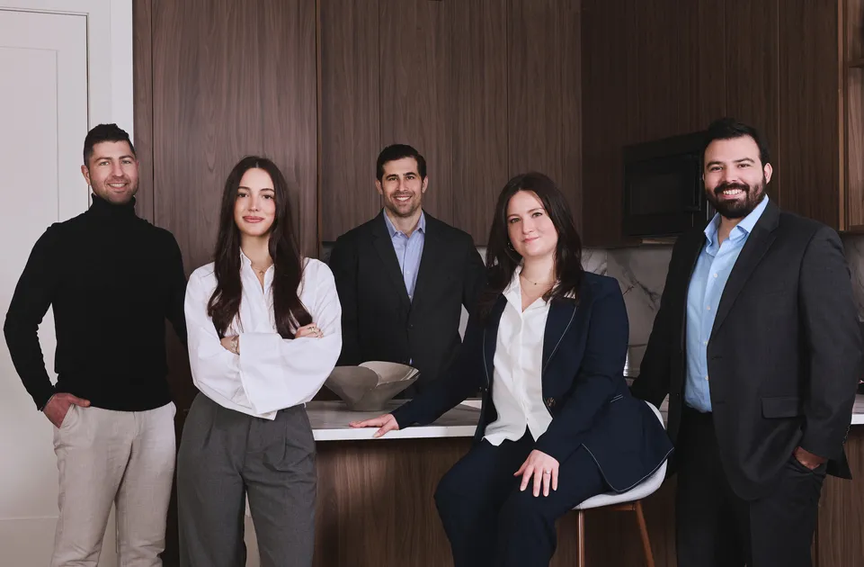 The Finelli Team real estate agents standing together in a modern NYC kitchen