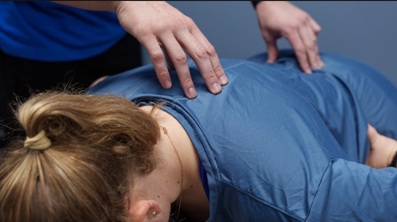 physical therapist guiding a patient through a functional movement assessmen