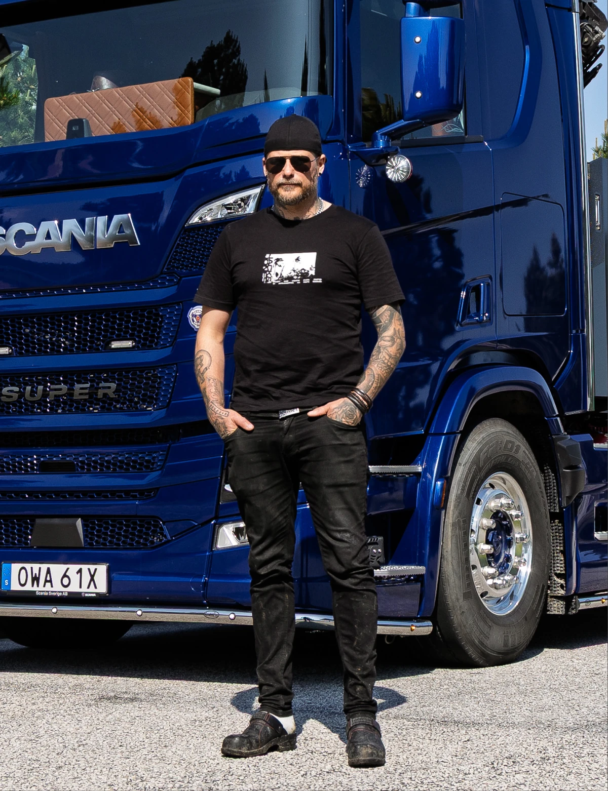 Chaufför från Wigrens entreprenad framför en blå Scania-lastbil