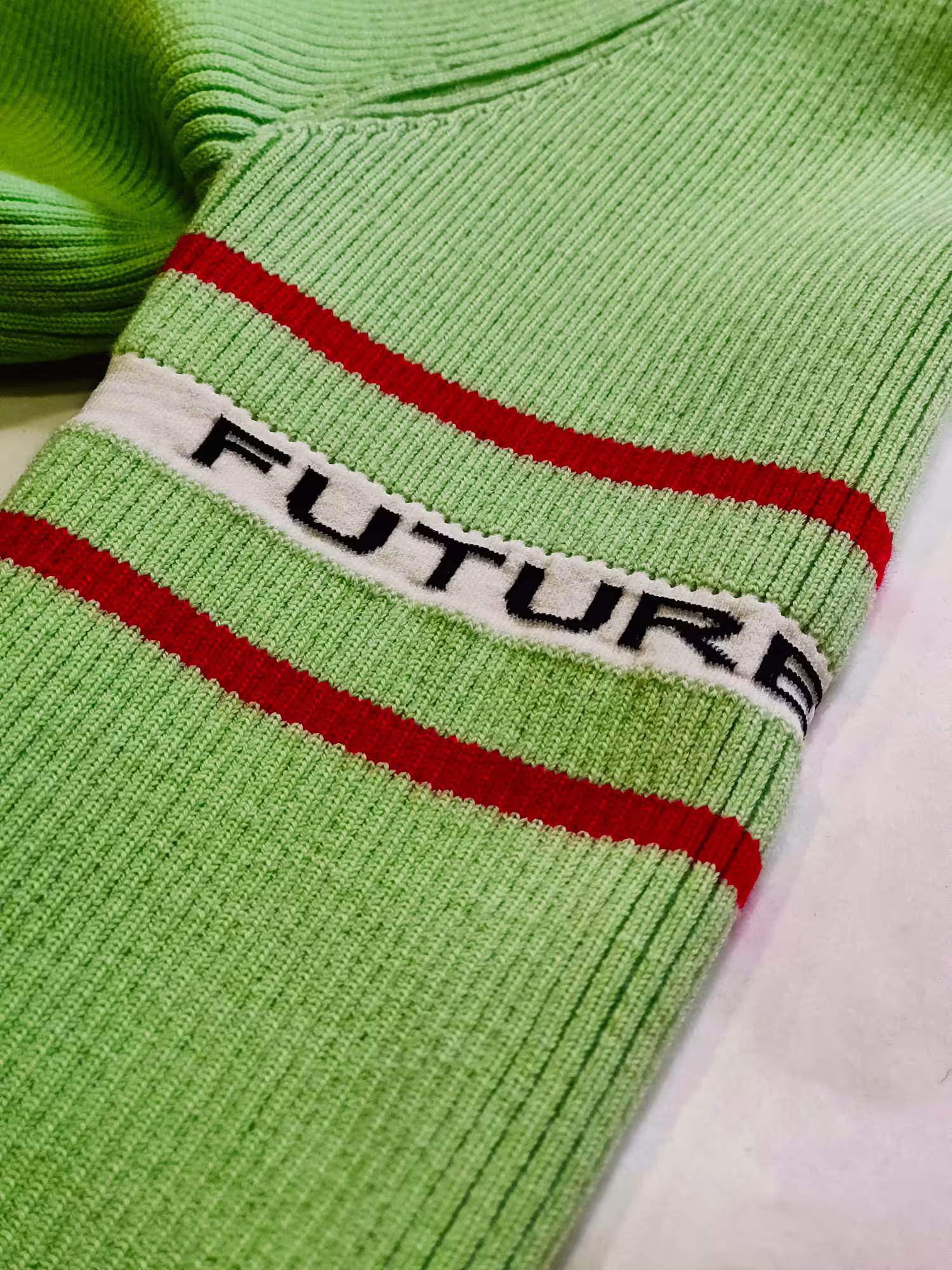 Maglia verde in lavorazione – rappresentazione dell’impegno di Max Company per la sostenibilità e l’innovazione tessile Made in Italy.