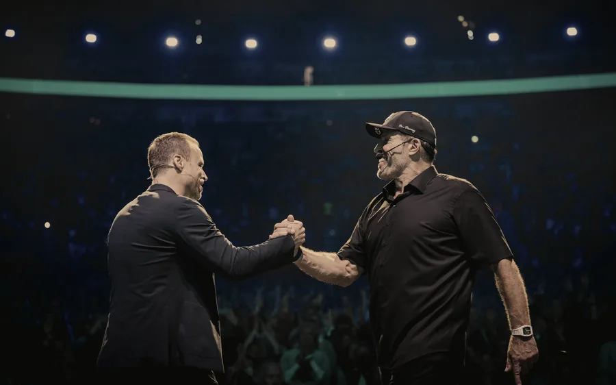 Tony Robbins und Greator beim Handschlag auf der Bühne des Greator Festival 2023