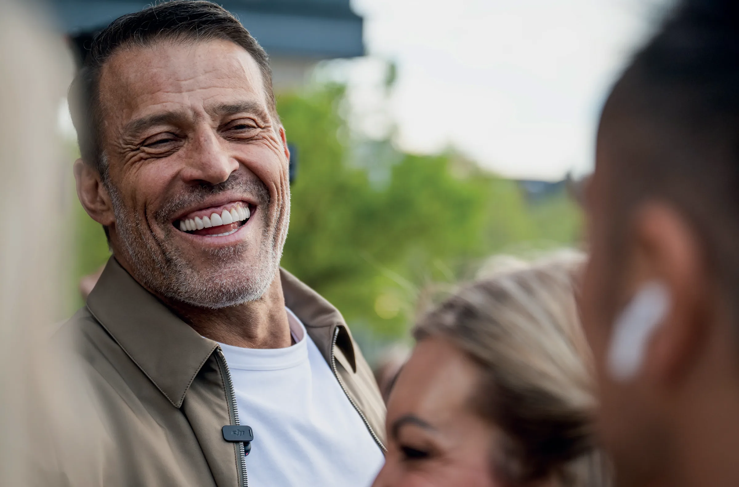 Tony Robbins lacht mit Teilnehmenden nach einer Session