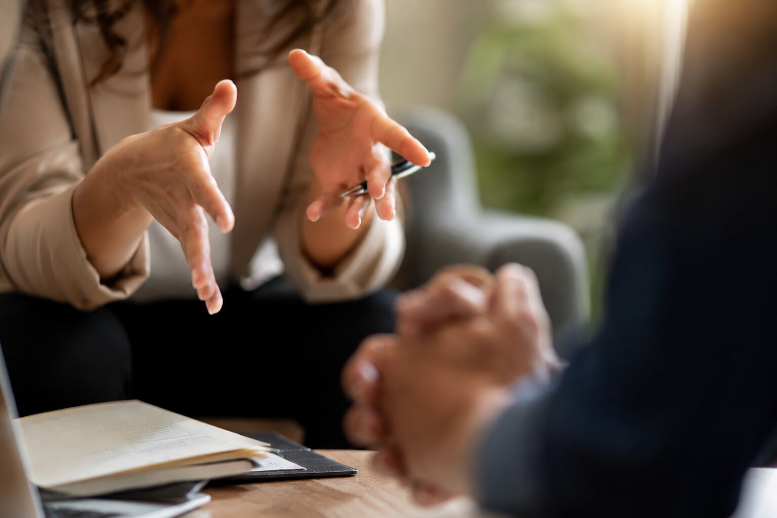 Close-up of a business coach using expressive hand gestures during a professional coaching conversation.