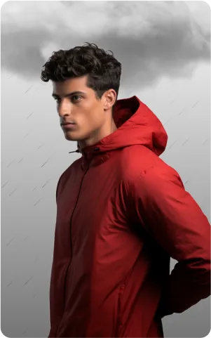 A man with curly hair poses in profile, wearing a red jacket, against a backdrop of dark clouds and rain.